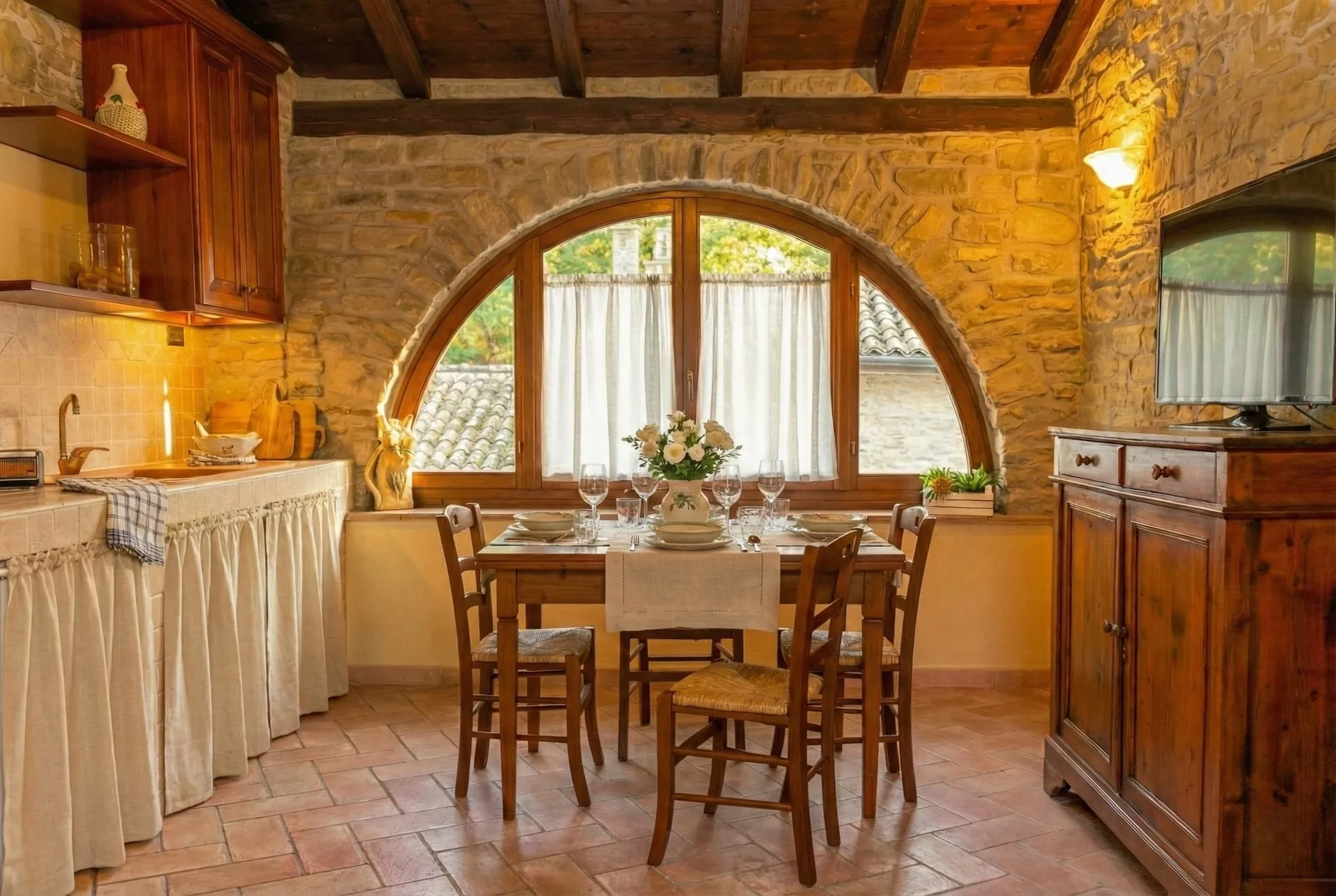 Soggiorno dell'appartamento Voltone con grande finestra ad arco in pietra e tavolo apparecchiato
